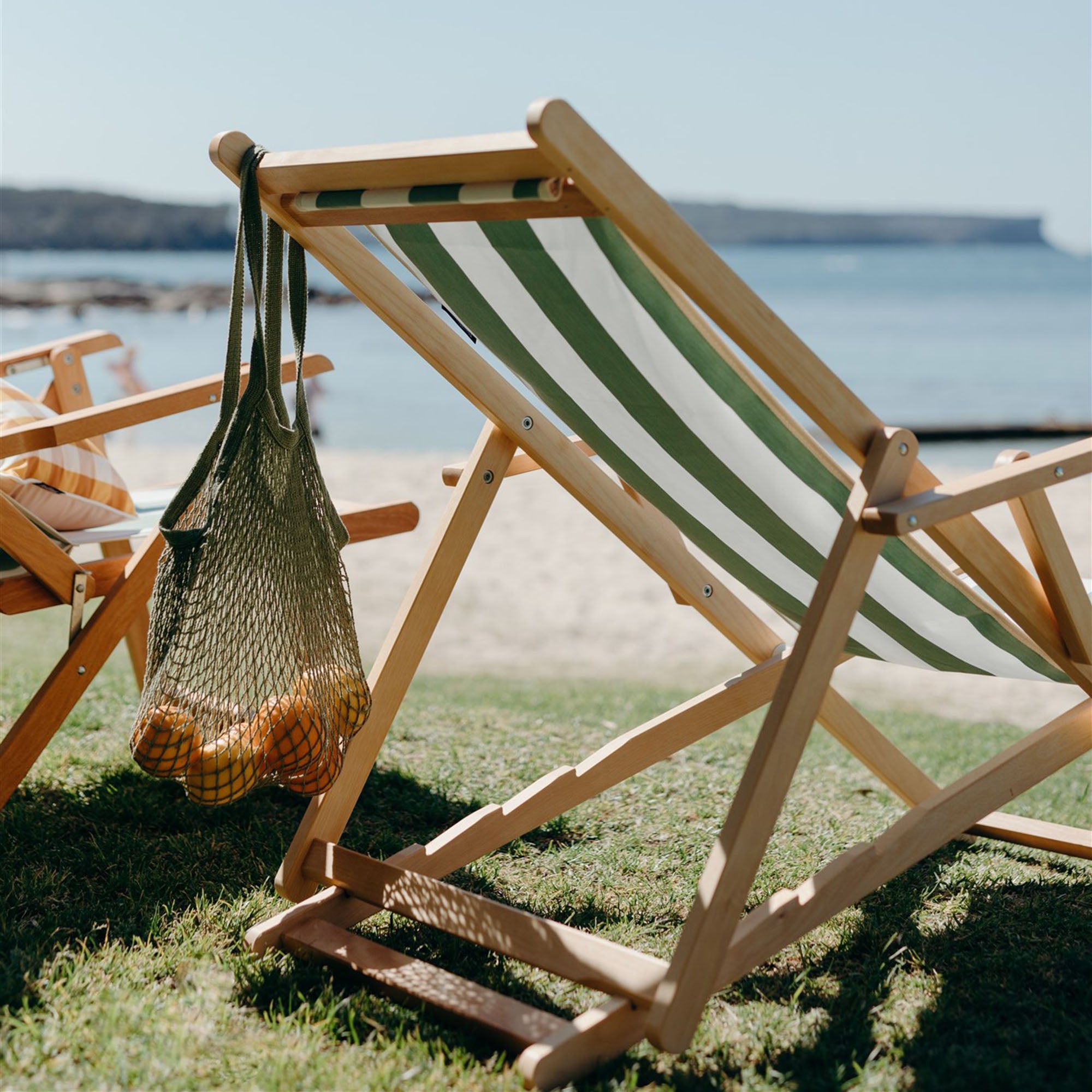 Basil Bangs Beppi Sling Chair in Amore Striped Forest by the beach side. 