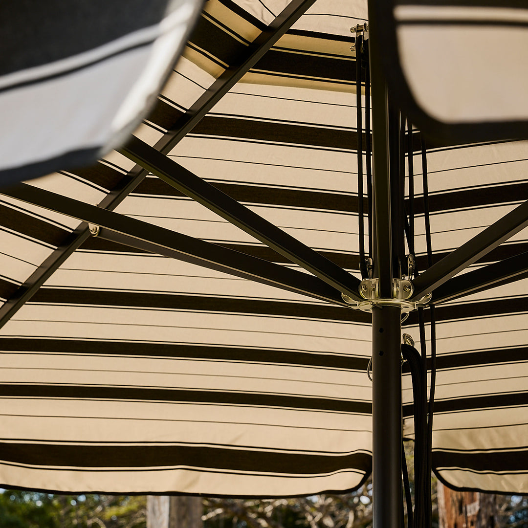 Basil Bangs commercial and residential black frame patio umbrella with black Al Mare stripe canopy