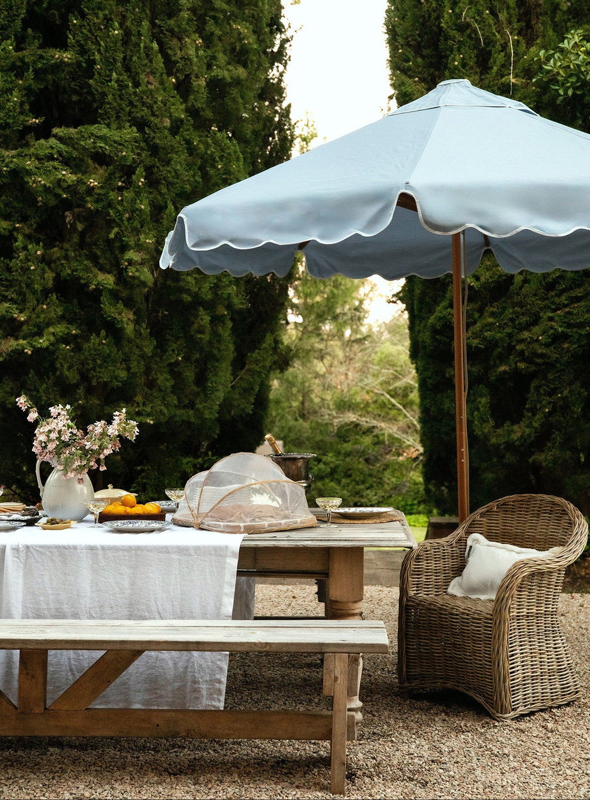 sundial scallop valance 2.8m dusk blue in rustic looking european countryside outdoor table setting