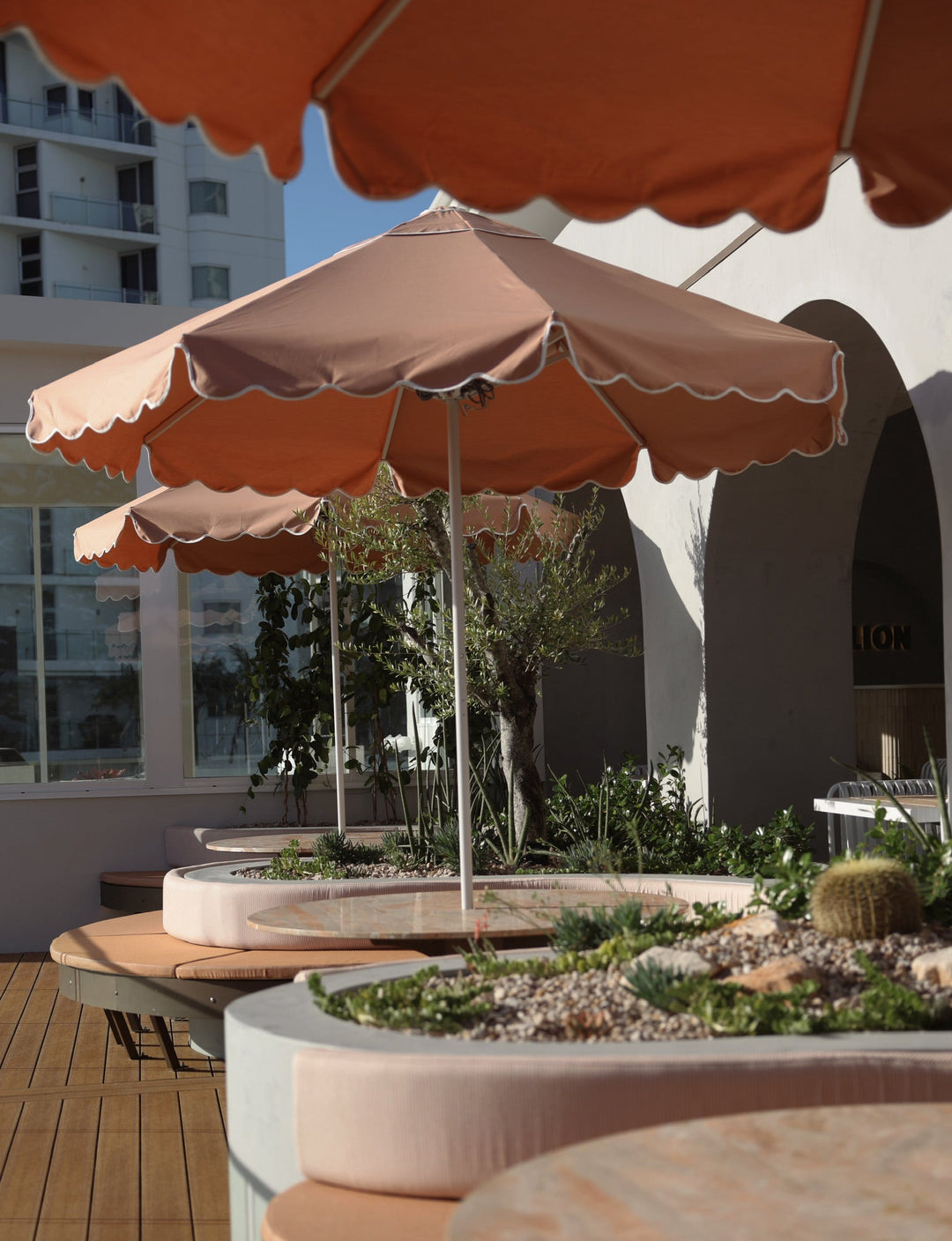 Basil Bangs 2.8m Sundial Umbrella with a soft Scallop valance in Clay at Pavilion Mooloolaba
