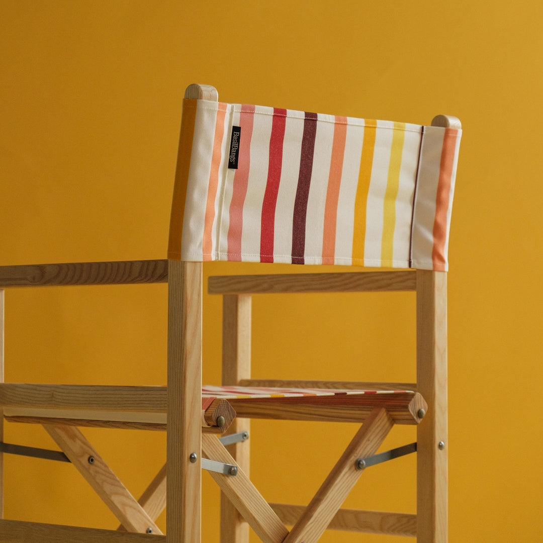 Timber Director's Chair in multi colour stripes against a yellow background
